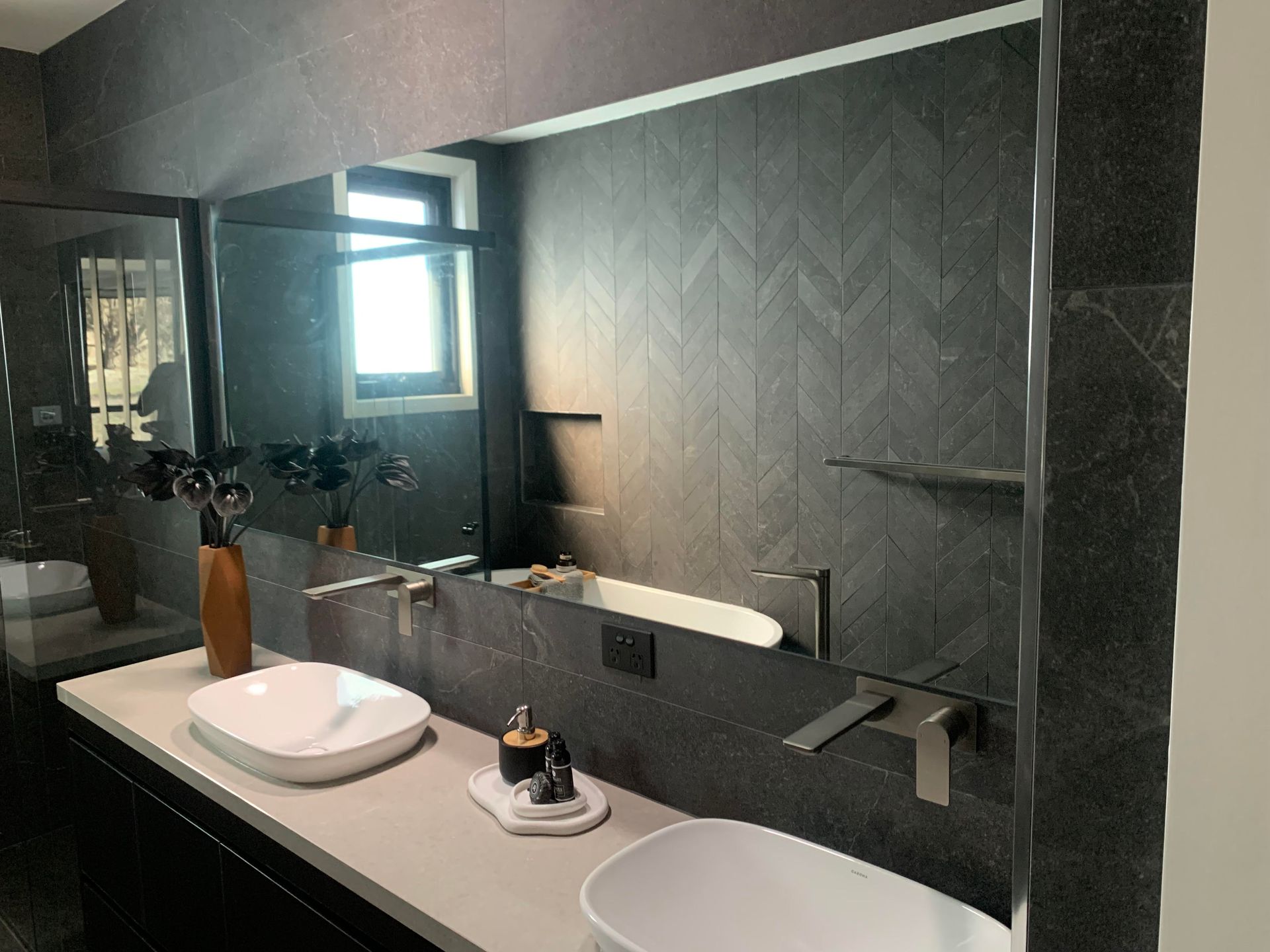 A bathroom with two sinks and a large mirror.