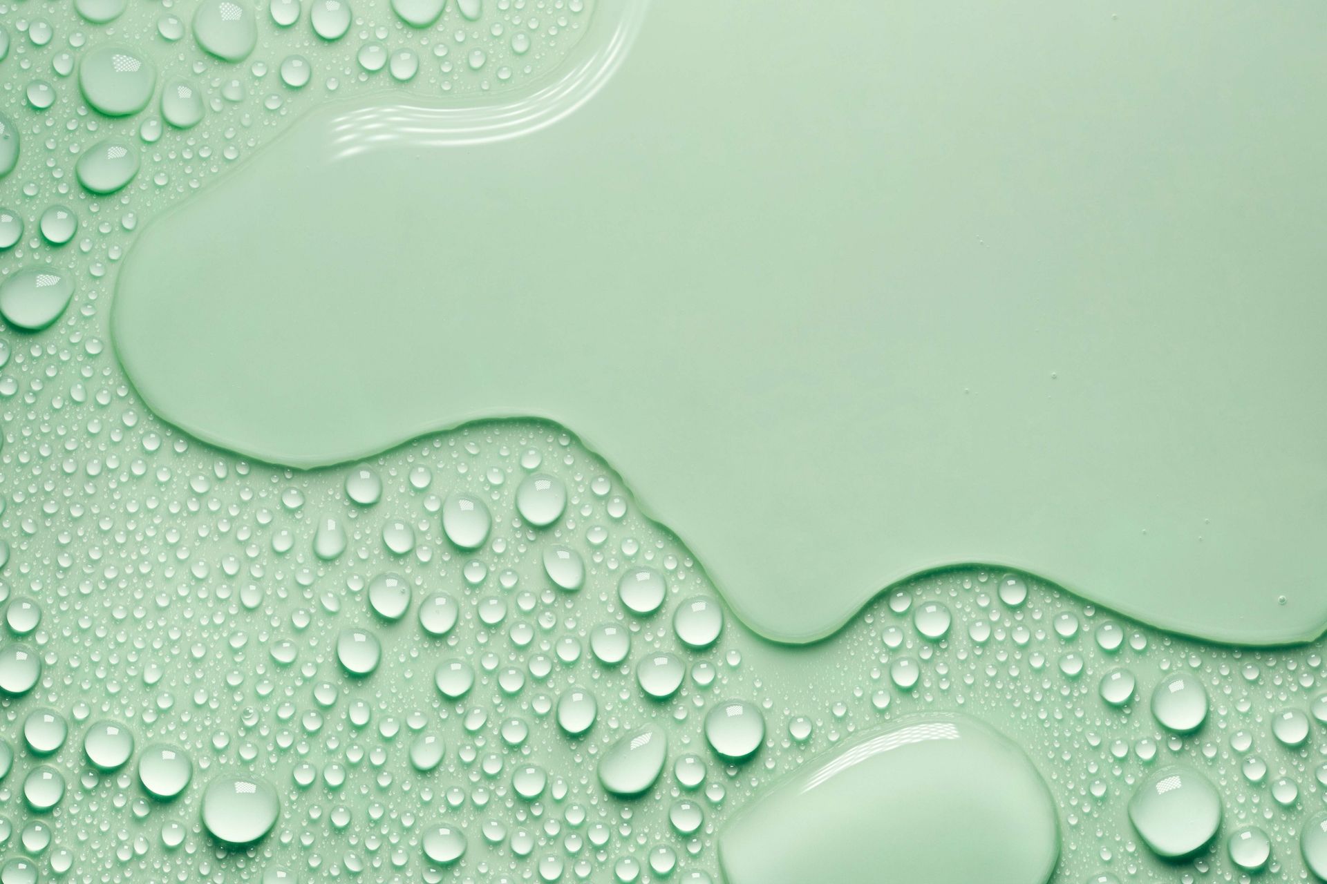 Eine Nahaufnahme von Wassertropfen auf einer grünen Oberfläche.