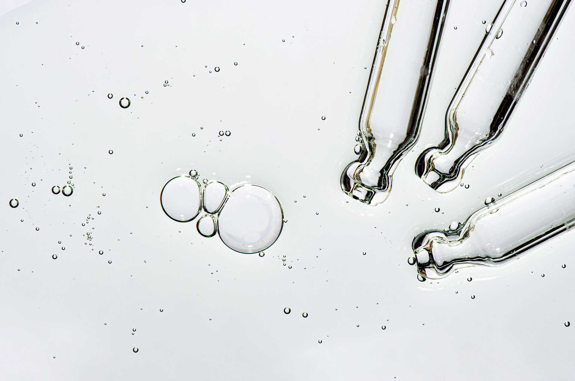 Eine Nahaufnahme einer mit Flüssigkeit gefüllten Pipette auf einer weißen Oberfläche.