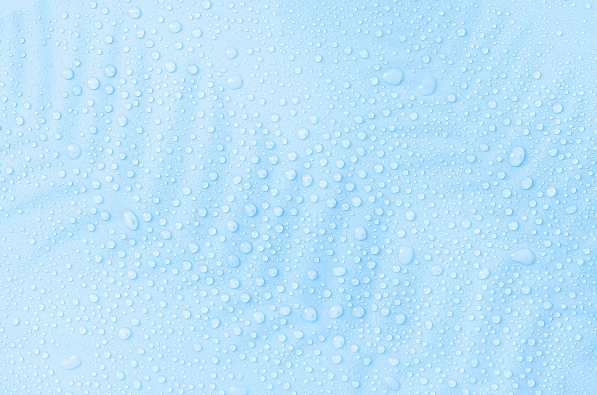 Wassertropfen auf einer hellblauen Oberfläche.