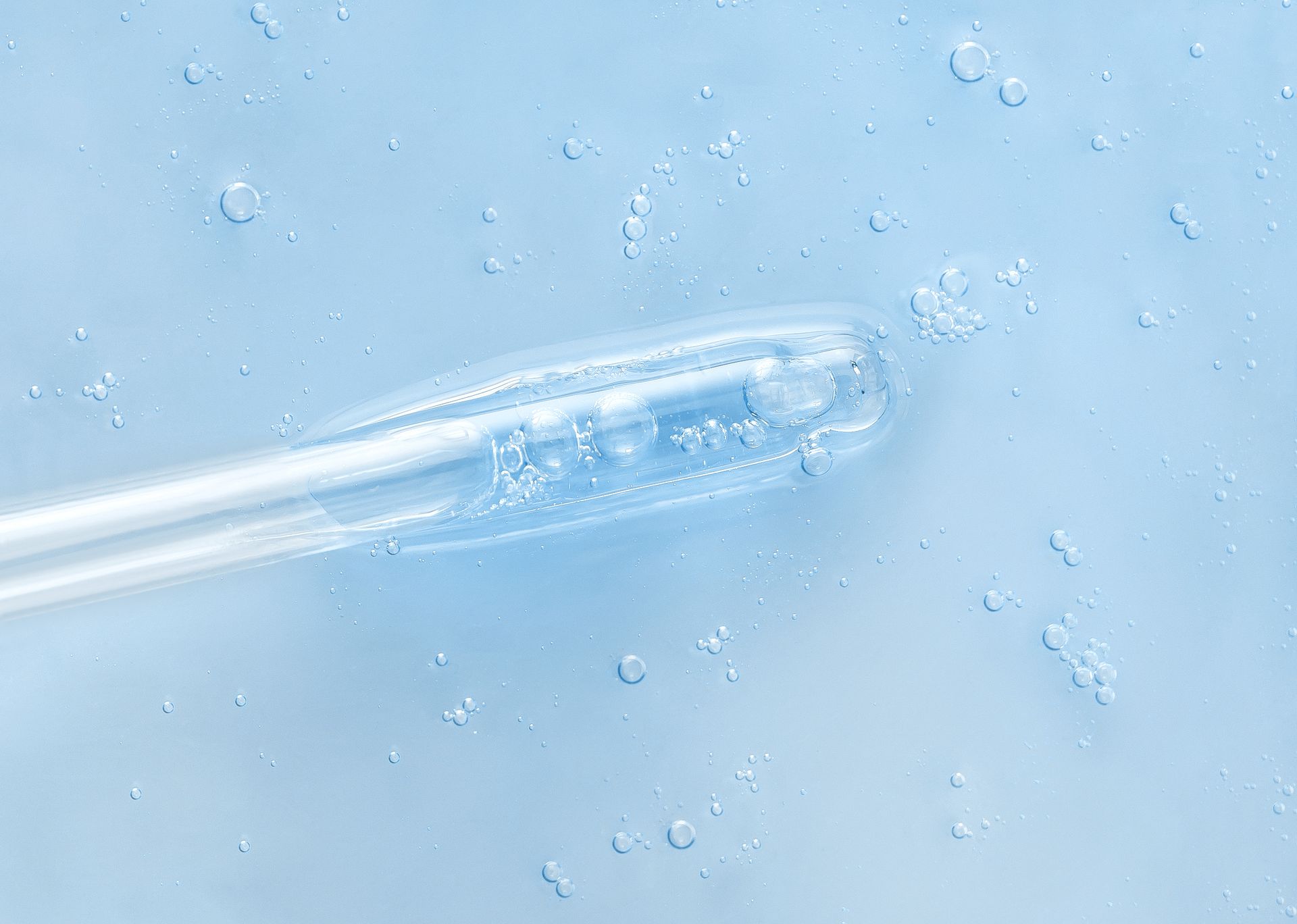 Eine Nahaufnahme einer Pipette in einer blauen Flüssigkeit.