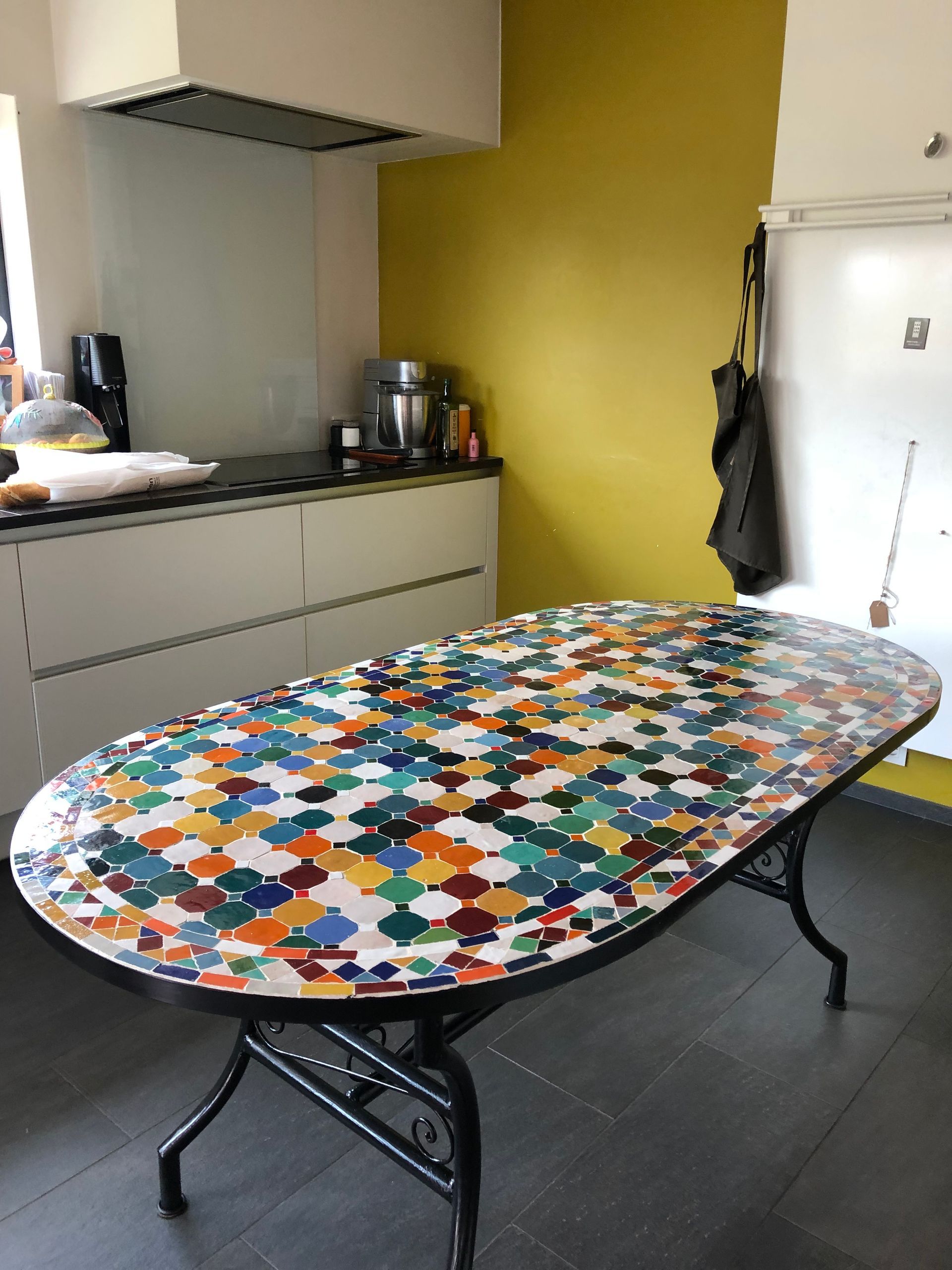Ovale tafel met kleurrijk Marokkaans mozaïekblad in een keuken.