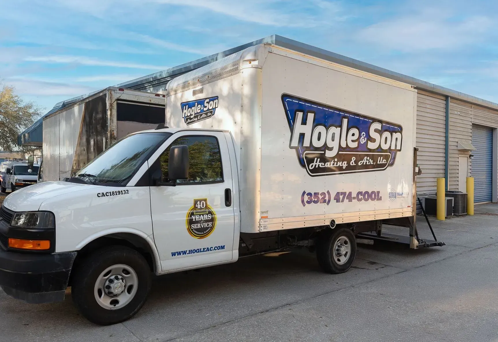 White Hogie & Son box truck parked outside a building. Contact info is visible.