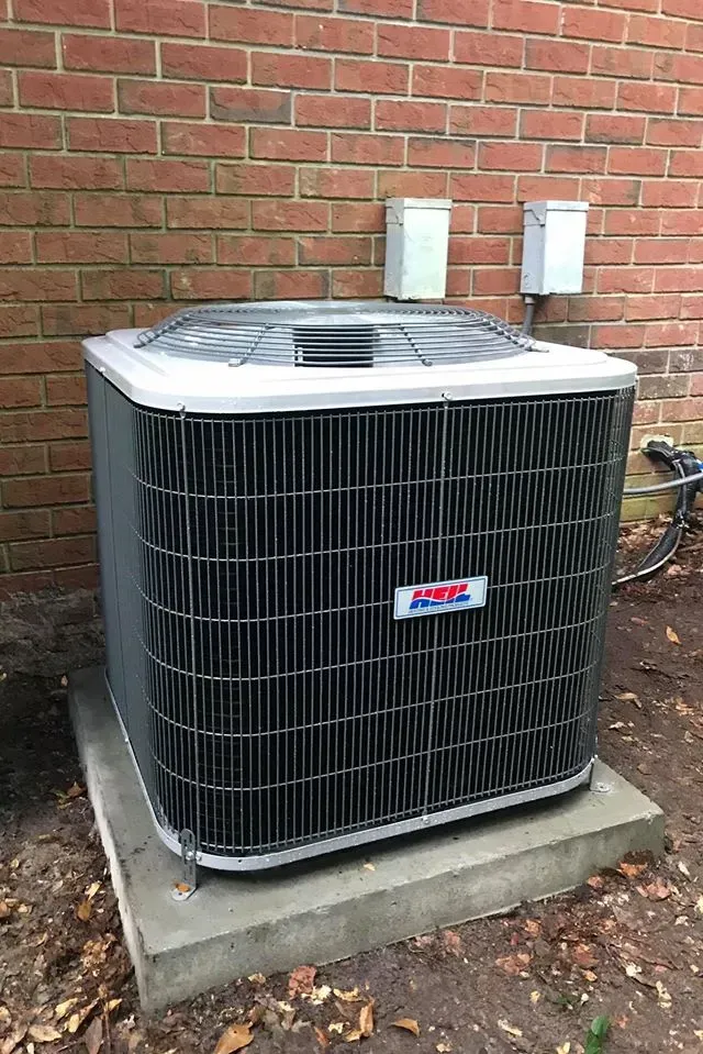 Air conditioning unit outside a brick building.