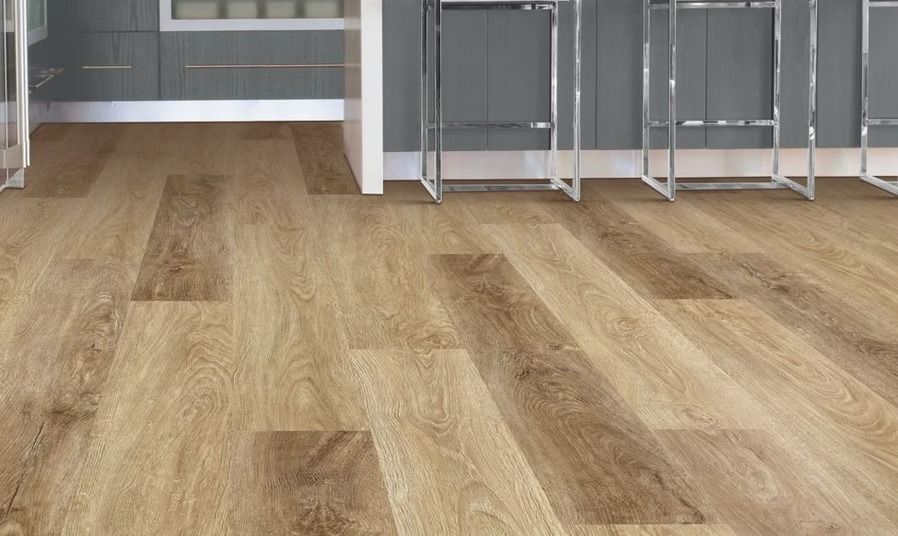 Wooden floor with a light brown tone, next to a counter and gray wall.