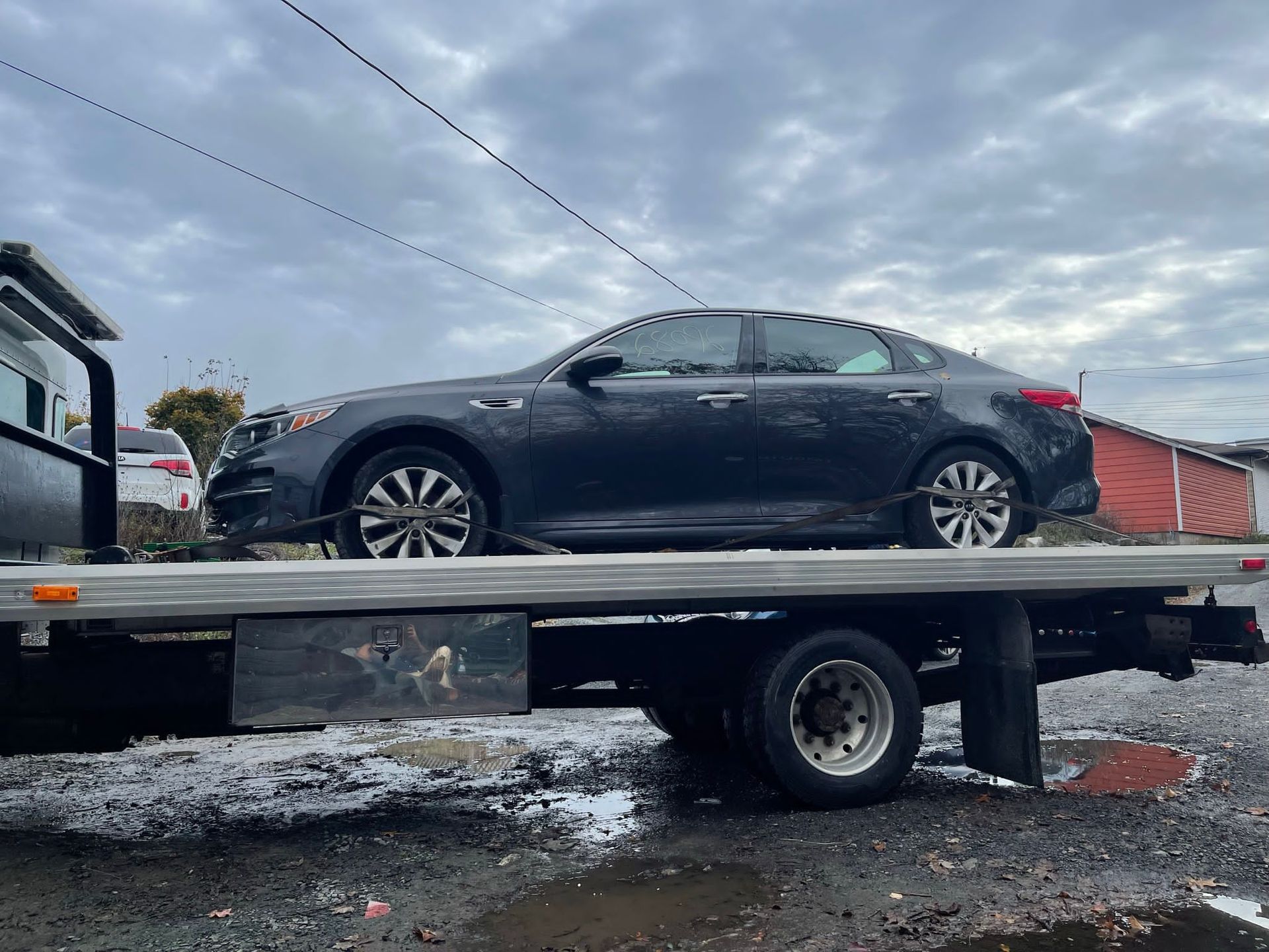 a car being towed with a flatbed tow truck