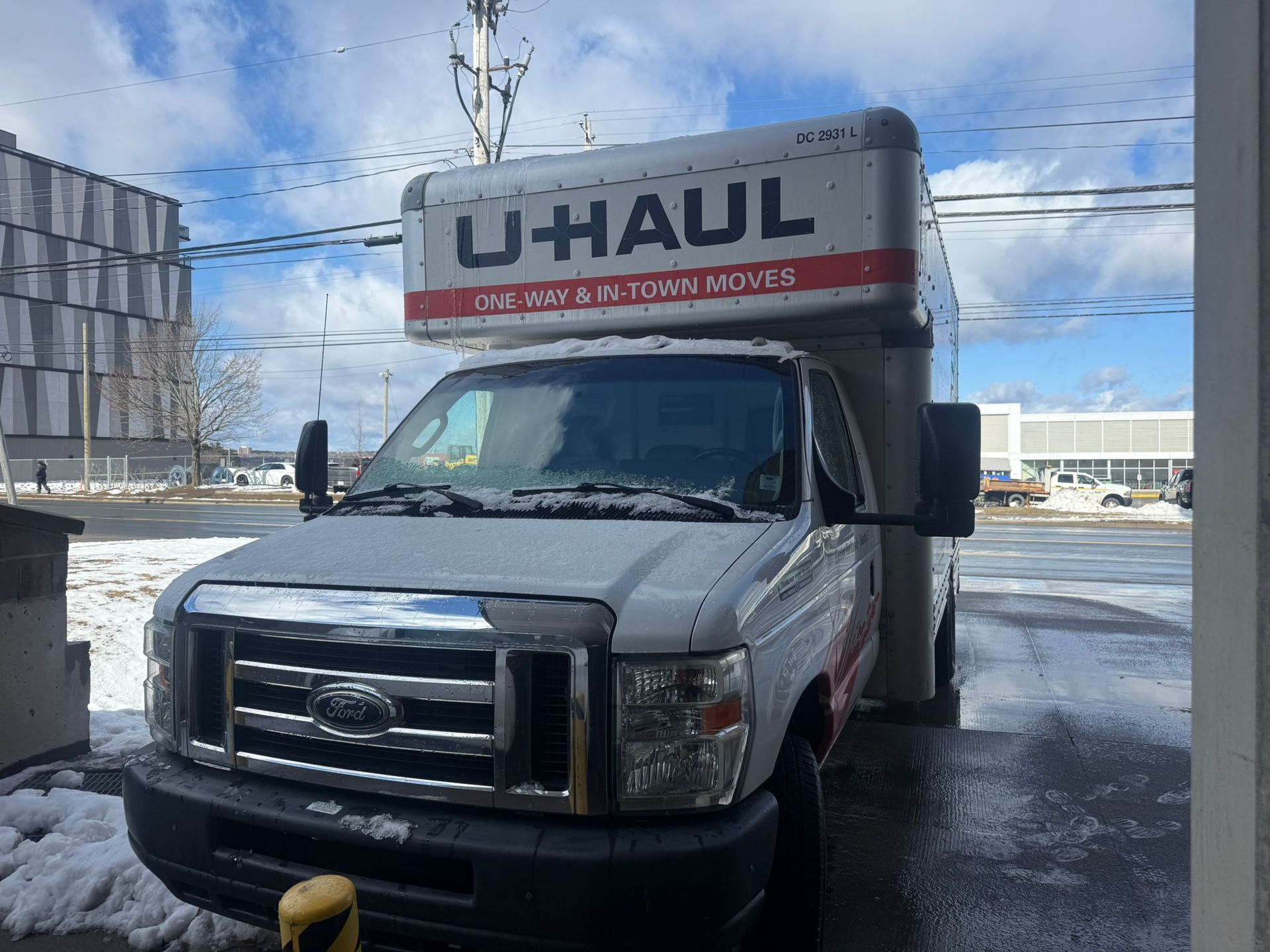 U-Haul box truck parked in a snowy lot on a sunny day