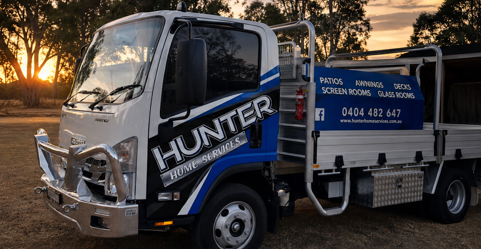 White utility truck with “HUNTER” branding parked outdoors at sunset