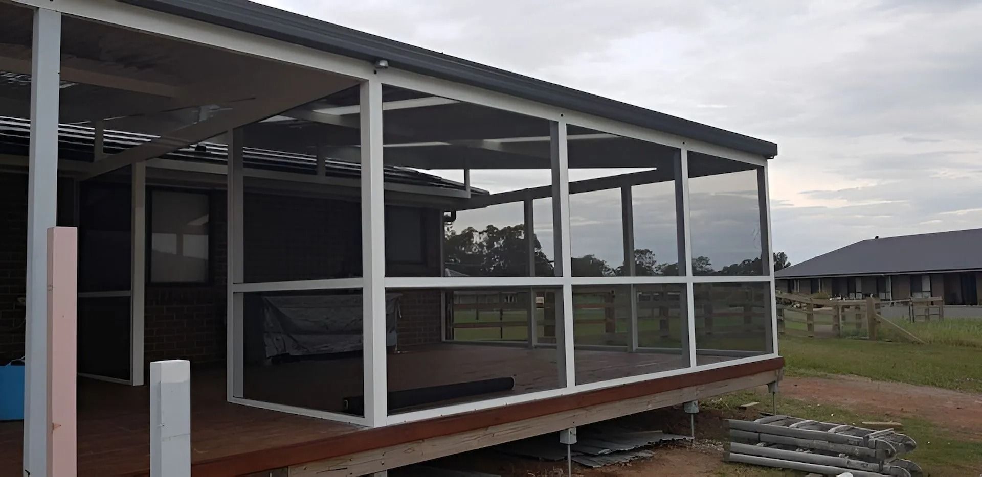 Modern house with large glass sliding doors and a covered porch under construction