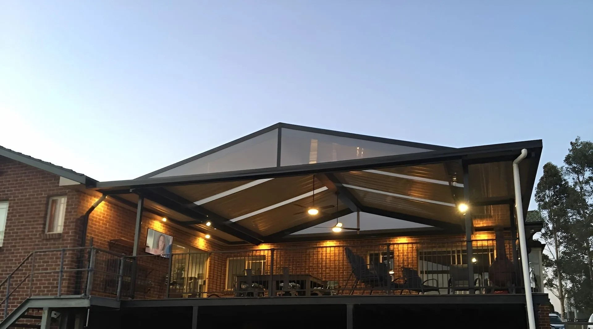 Outdoor patio with warm string lights under a covered roof at dusk