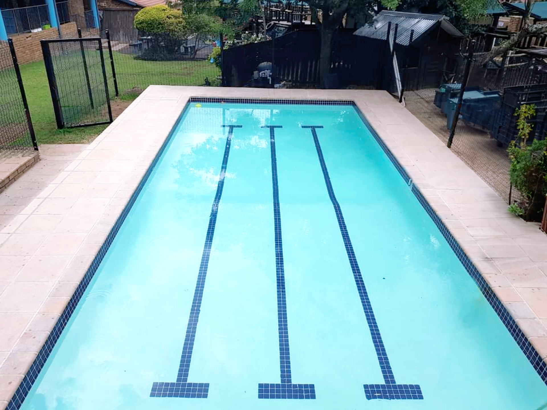 A large swimming pool with a fence around it