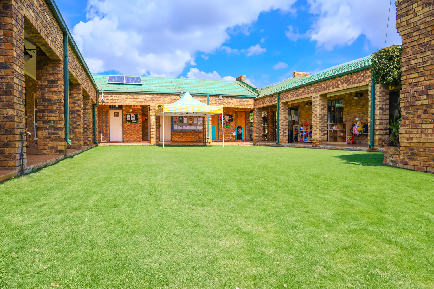 A large brick building with a large lawn in front of it.