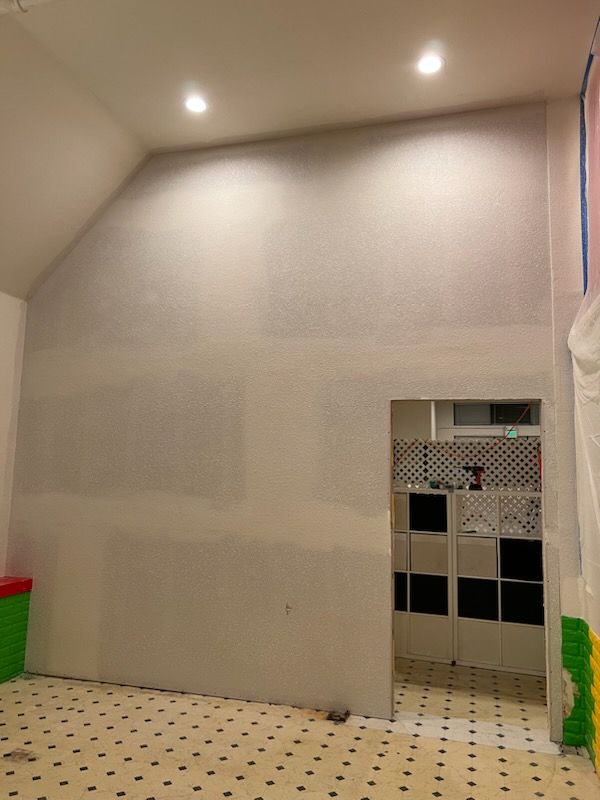 A room with a slanted ceiling and a polka dot floor.