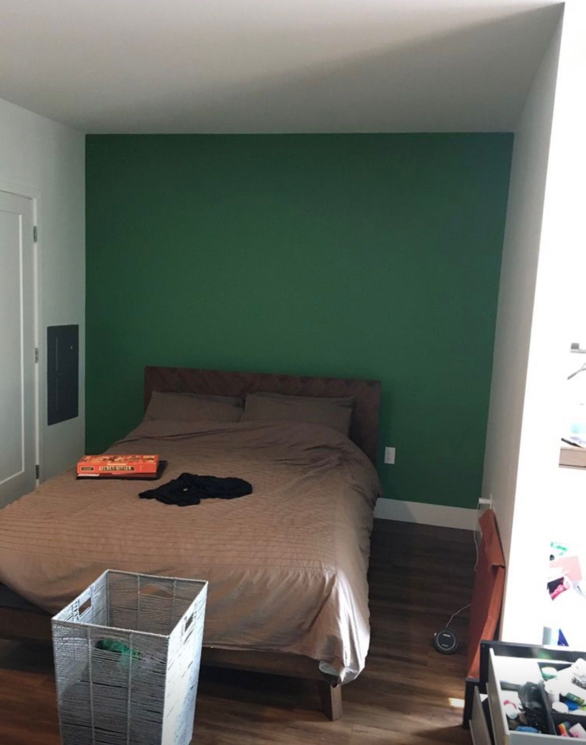A bedroom with a bed and a green wall.