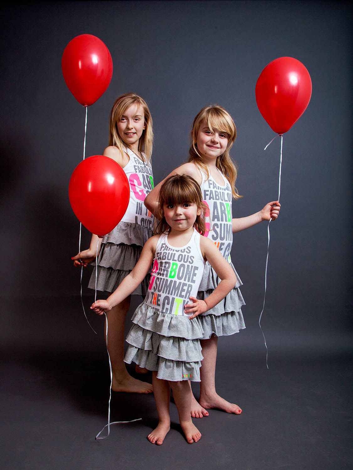 Drie meisjes met rode ballonnen