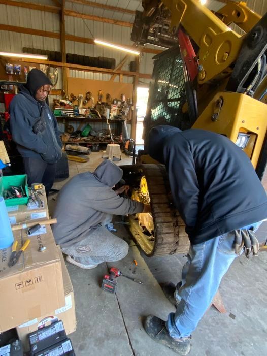A group of men are working on a machine in a garage.