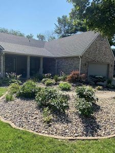 A house with a lot of plants in front of it.