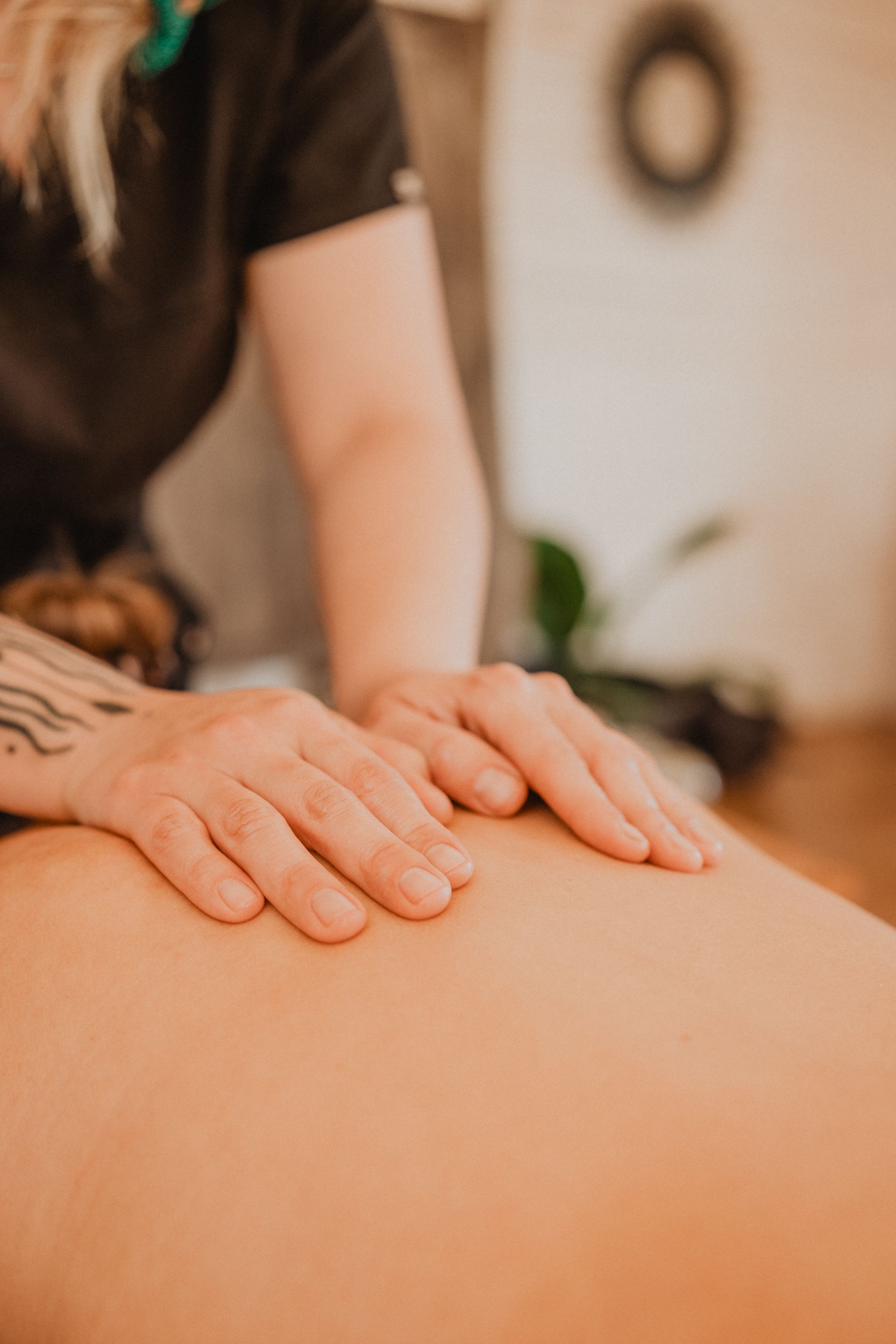 Manos dando un masaje de espalda en una sala de spa