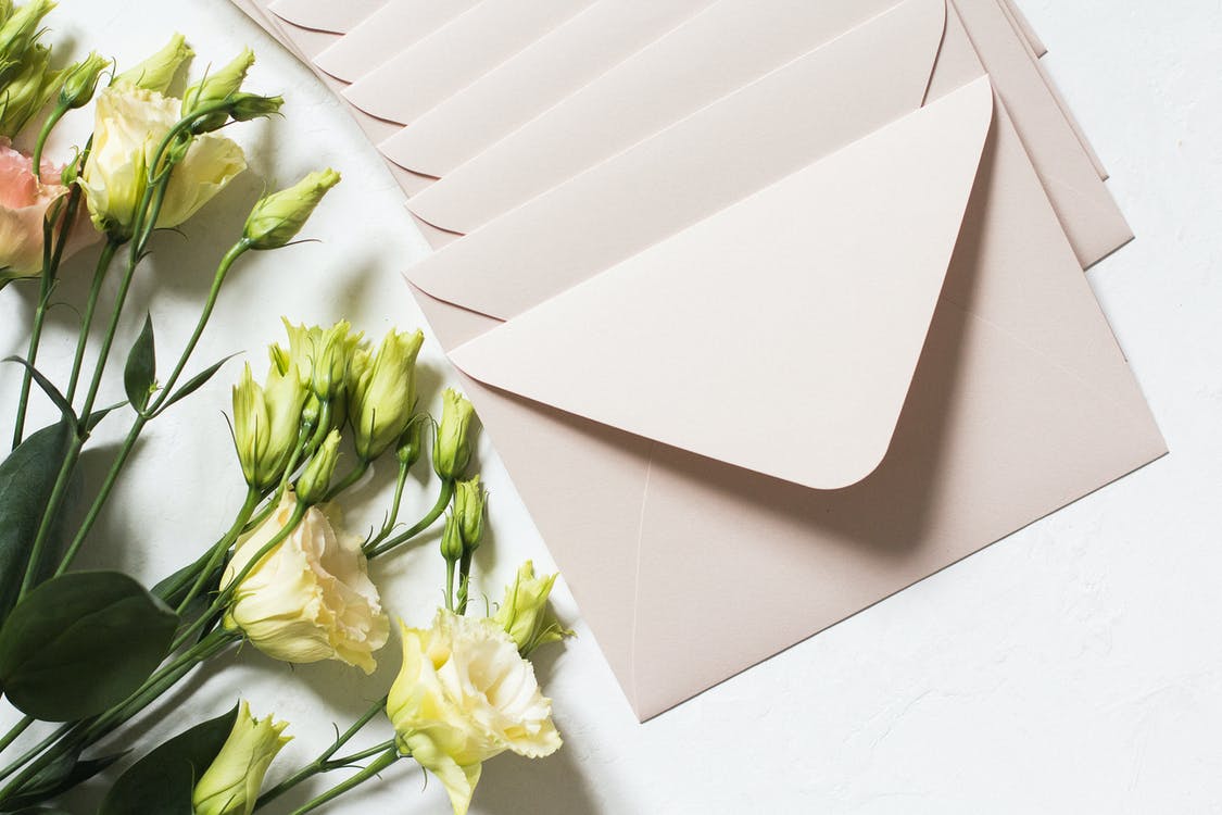 Beige envelope with cream flowers on a white background