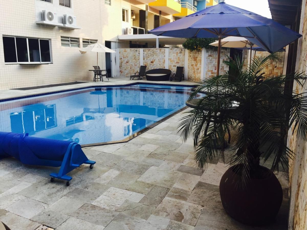 Uma grande piscina cercada por guarda-sóis e cadeiras