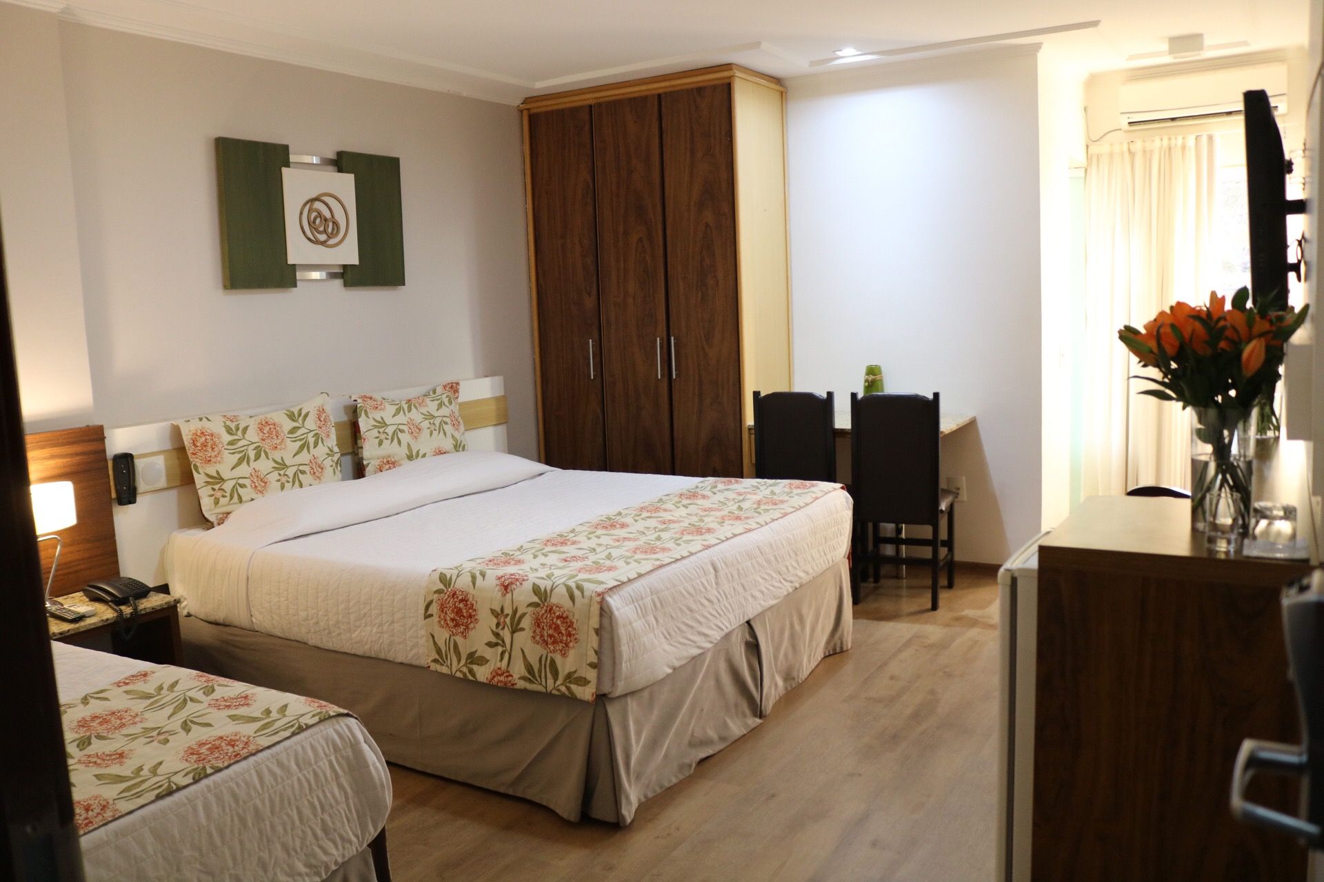 Um quarto de hotel com duas camas, uma mesa e cadeiras.