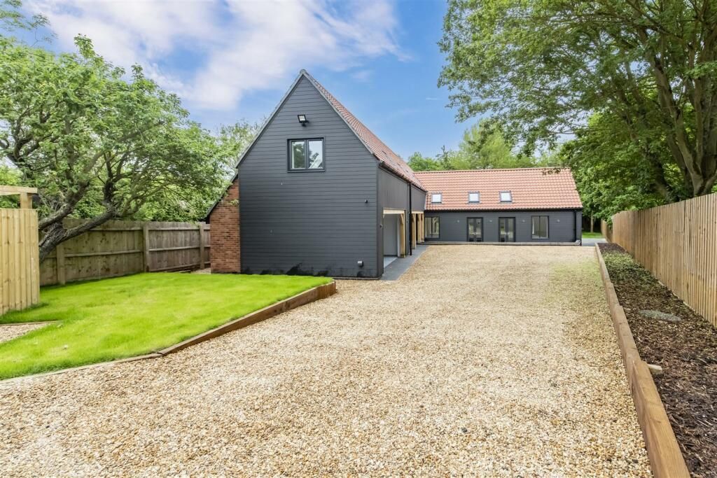 A large house with a gravel driveway leading to it