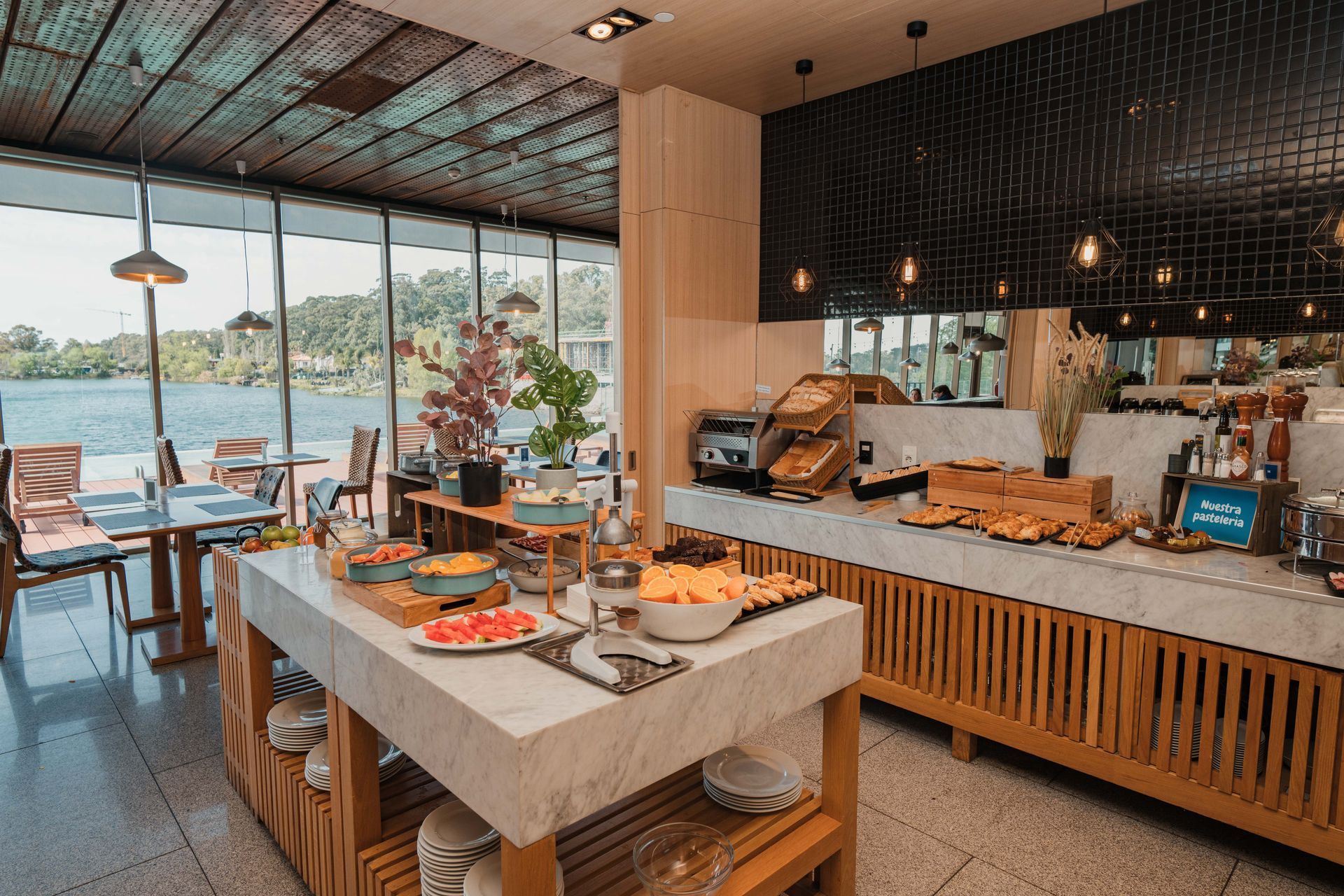 Una habitación de hotel con cama, silla, lámpara y ventana.