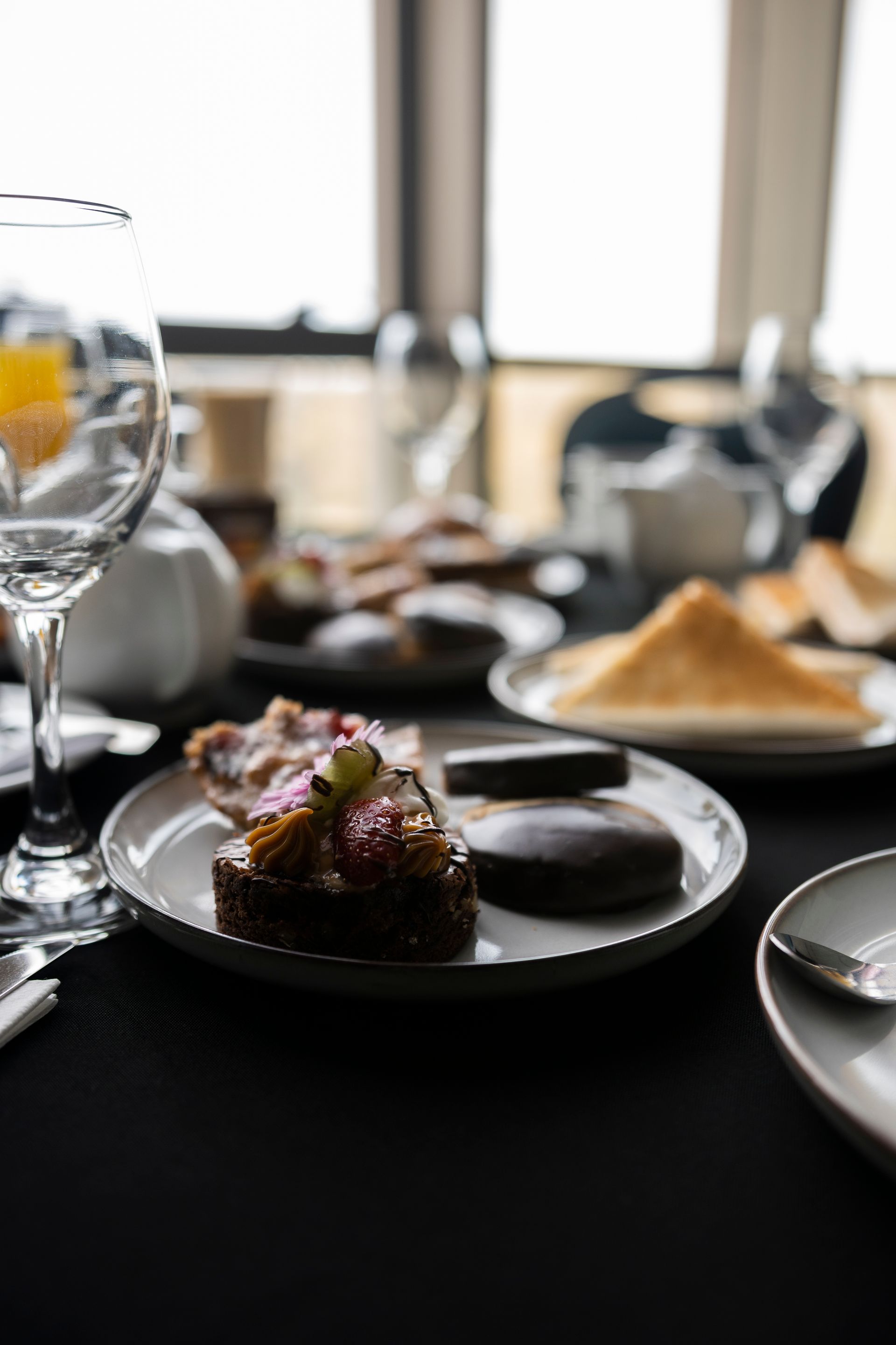 Una mesa cubierta con platos de comida y una copa de vino.