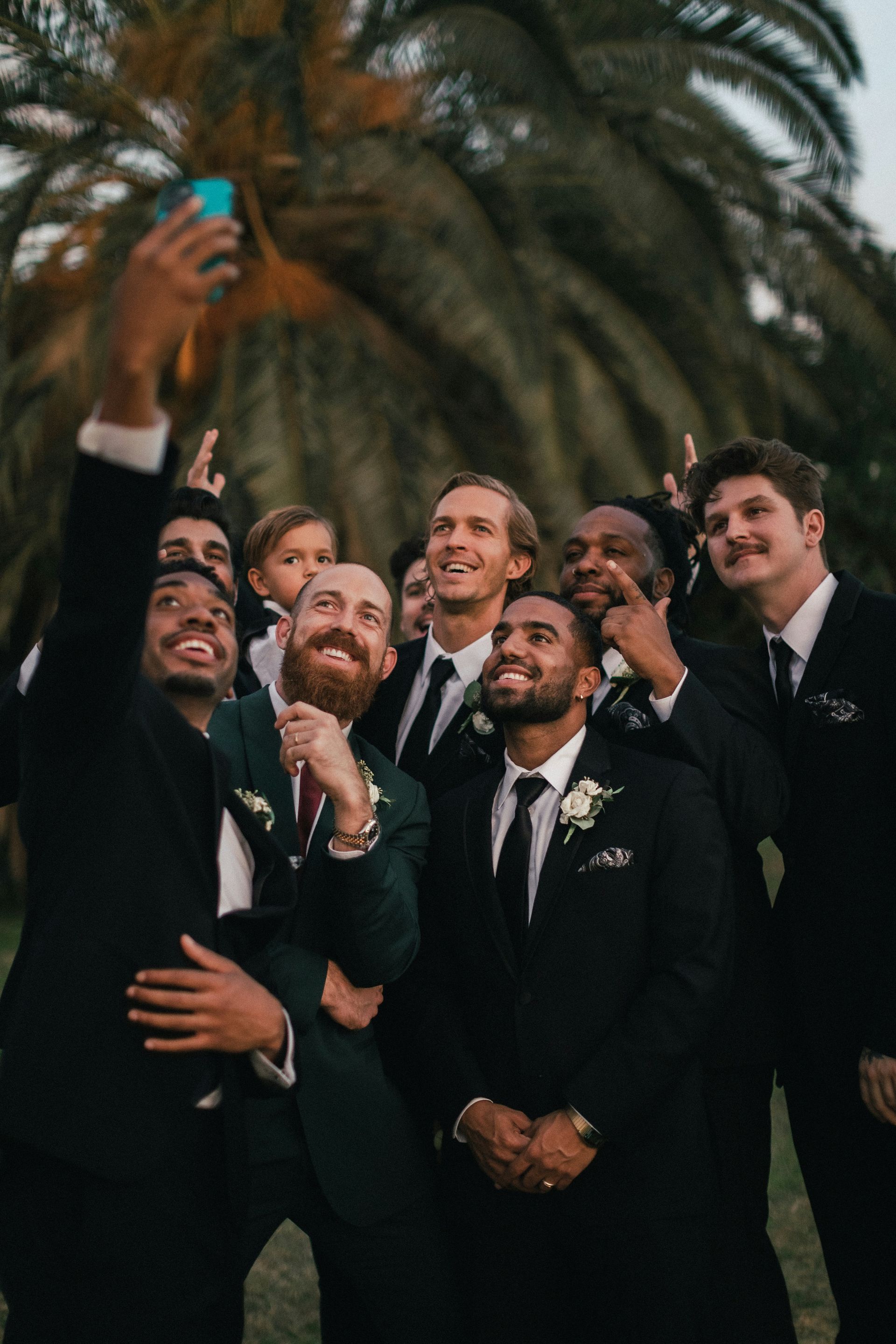 Tres jóvenes chocan los cinco mientras están parados junto a un lago.