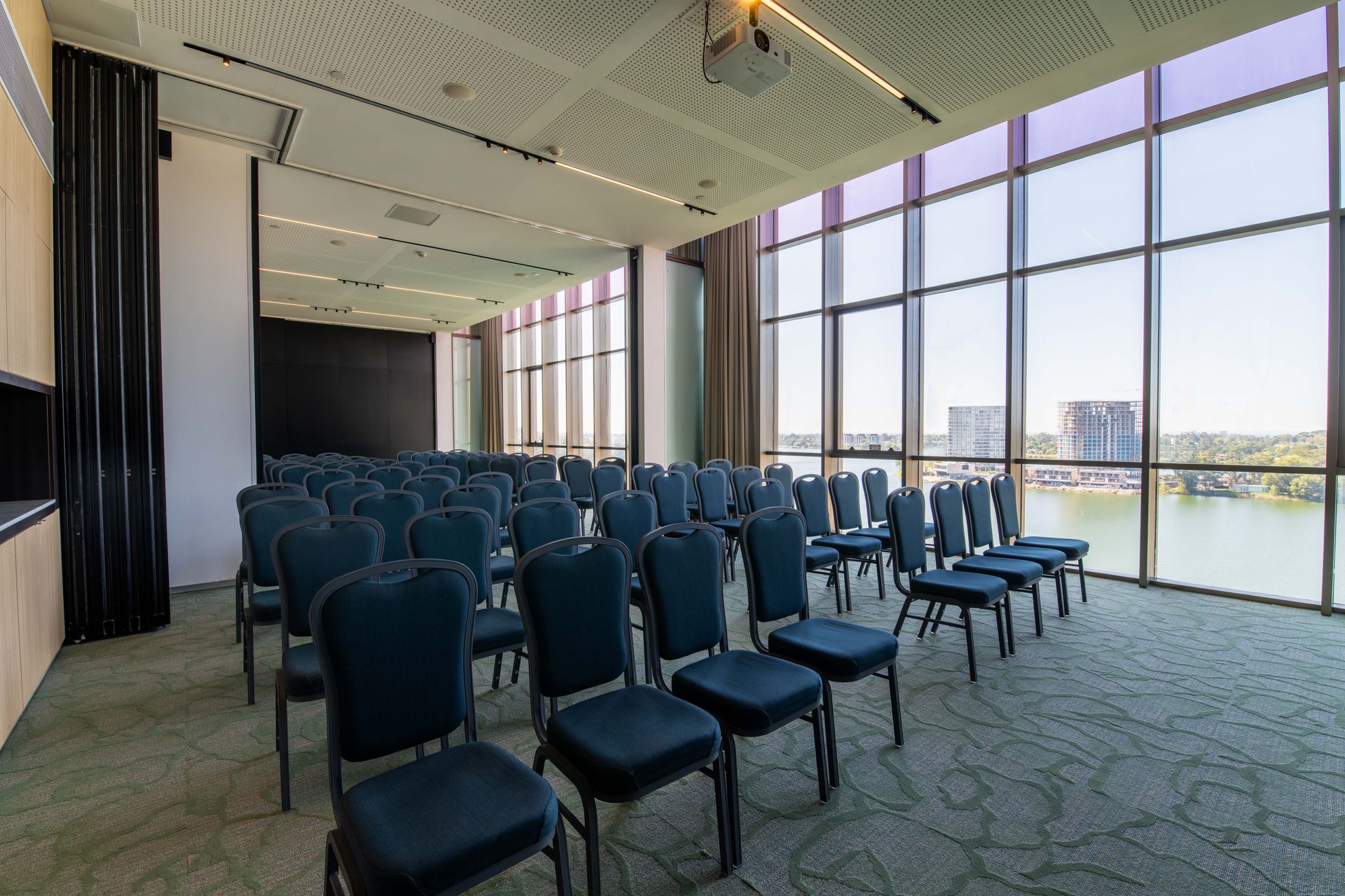 Una sala de conferencias con una mesa larga, sillas y un gran ventanal.