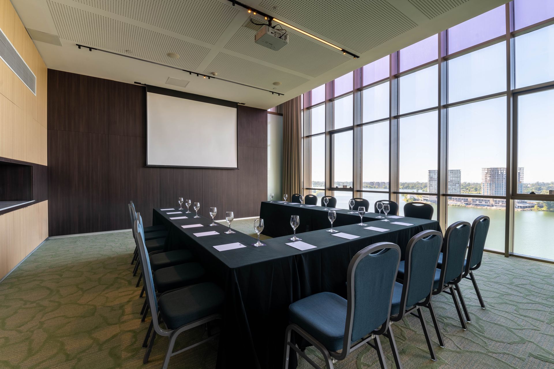 Una sala de conferencias con una mesa larga, sillas y un gran ventanal.