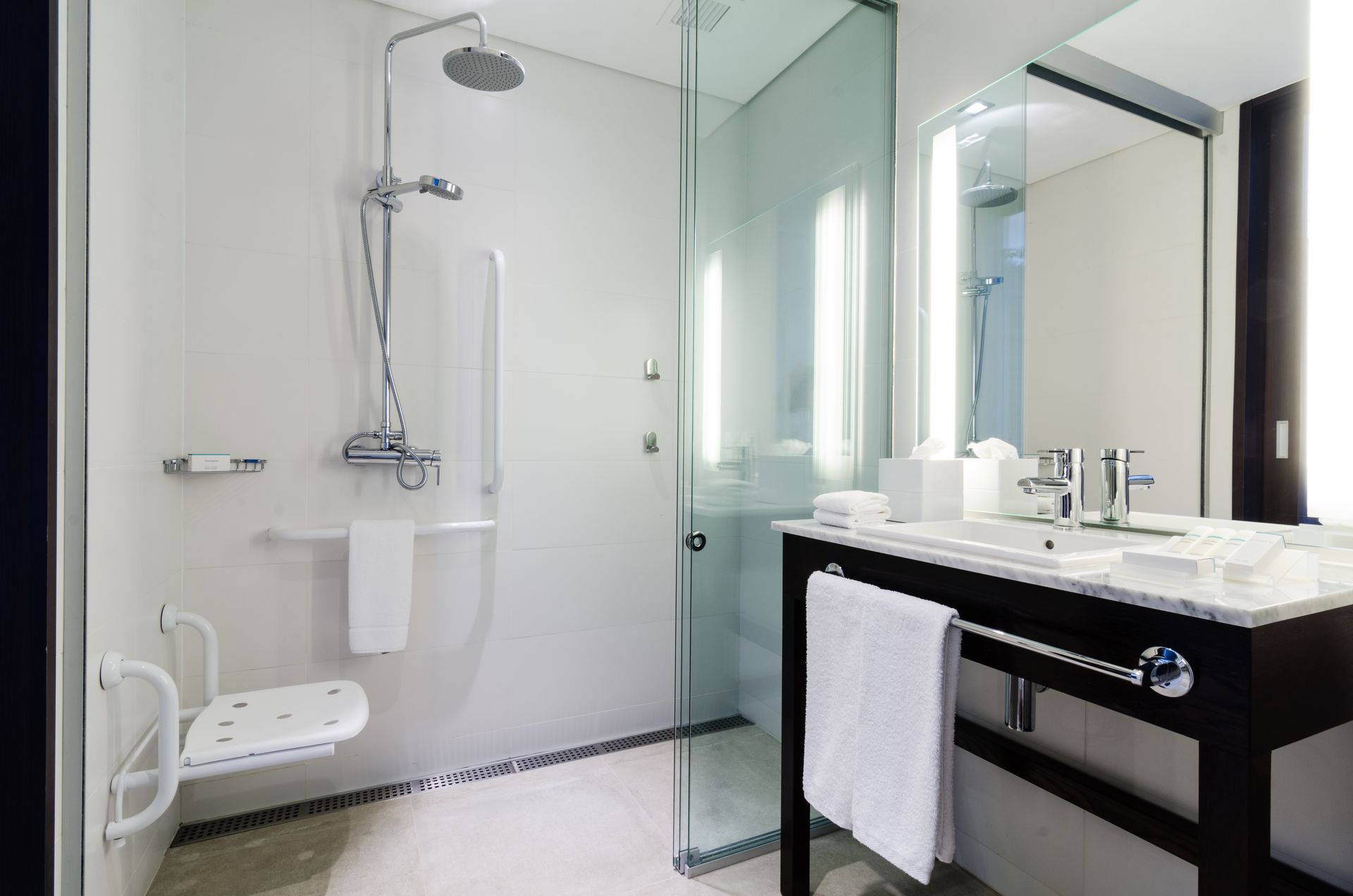 Un baño con plato de ducha, lavabo y espejo.