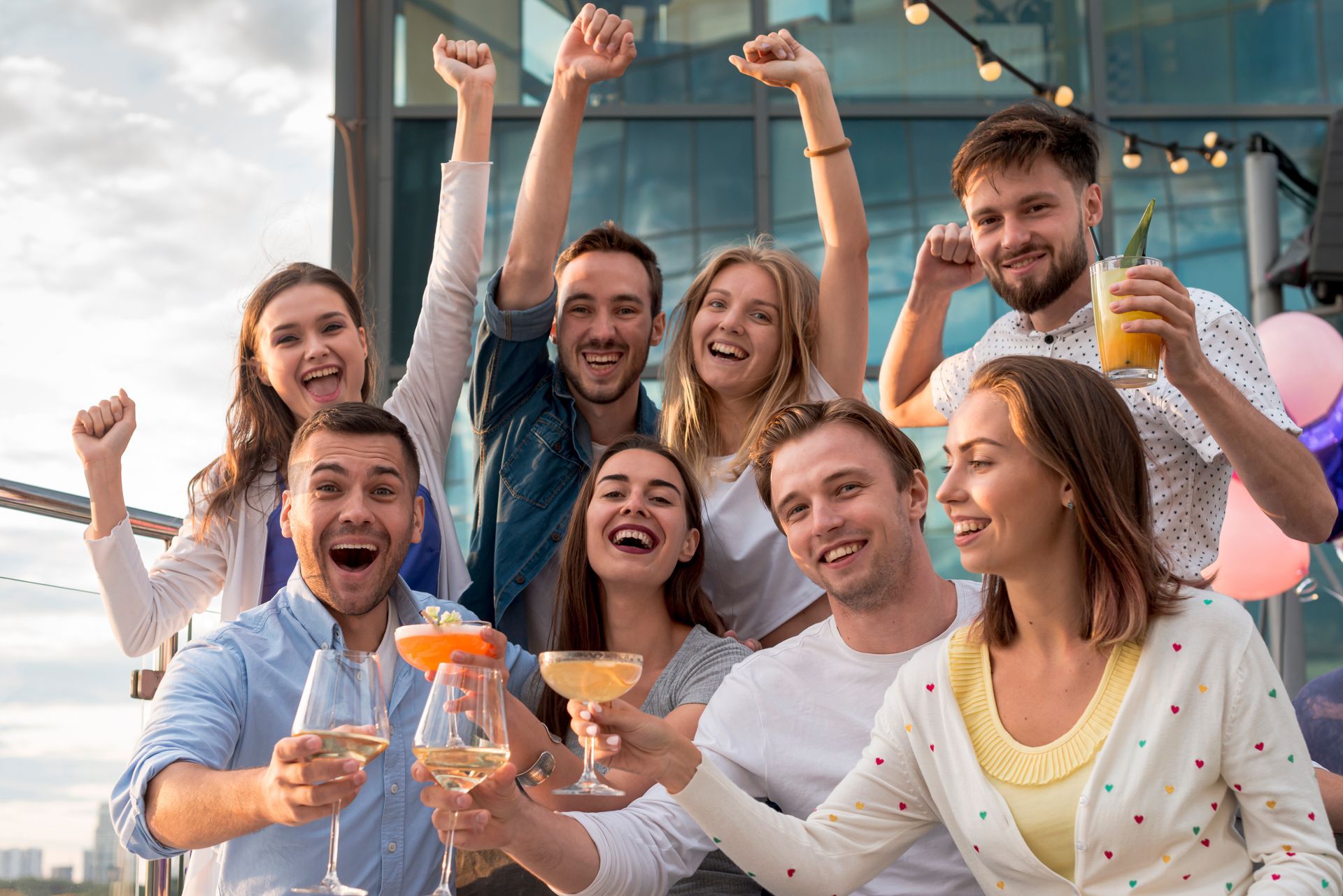 Un grupo de personas está sentada en un sofá brindando con bebidas.