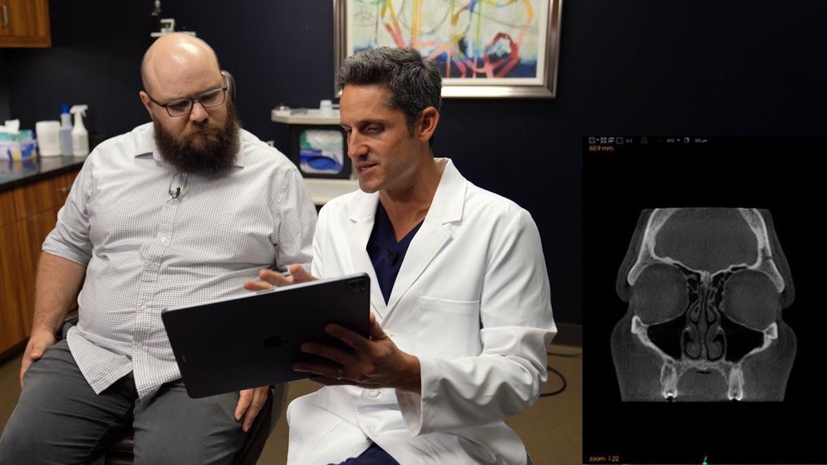 Doctor and patient reviewing a sinus ct scan beside a medical scan display