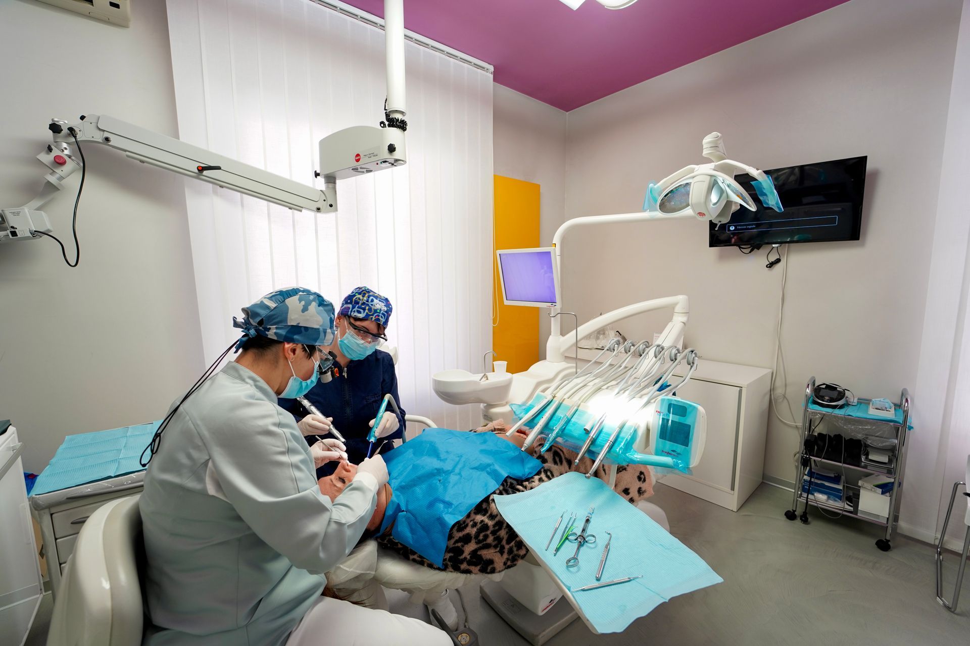 Dentista e assistente lavorano su un paziente in uno studio dentistico.