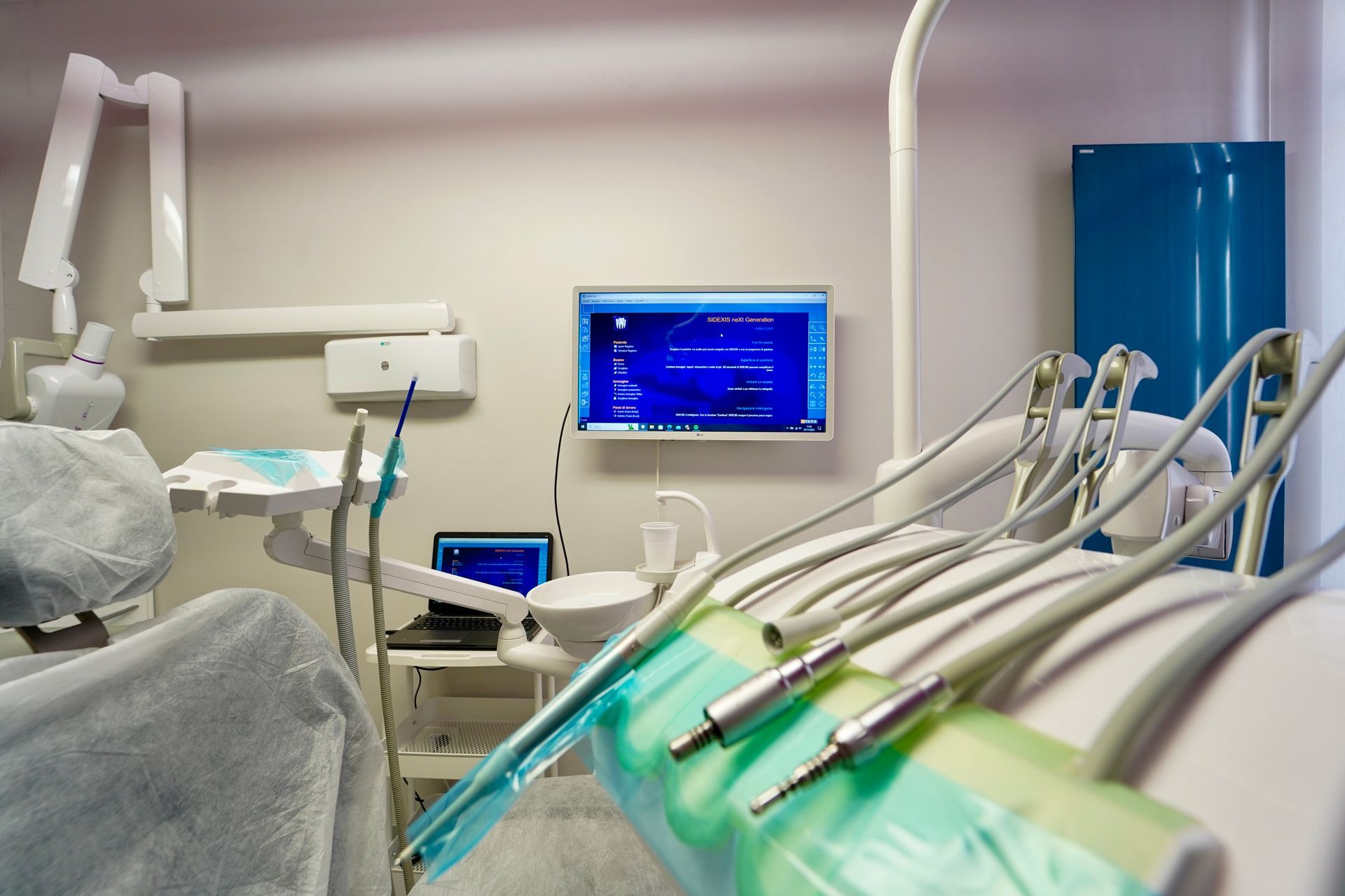 Poltrona odontoiatrica con strumenti, monitor che visualizza i dati, in uno studio pulito e ben illuminato.