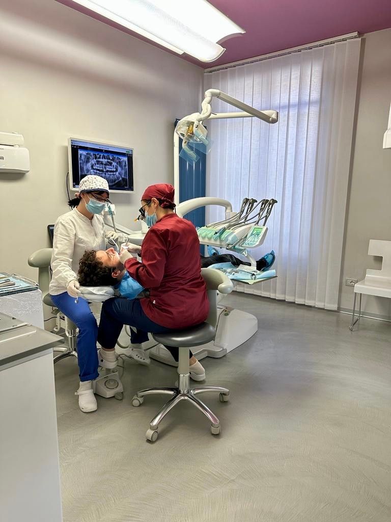 Due dentisti assistono un paziente nello studio dentistico.