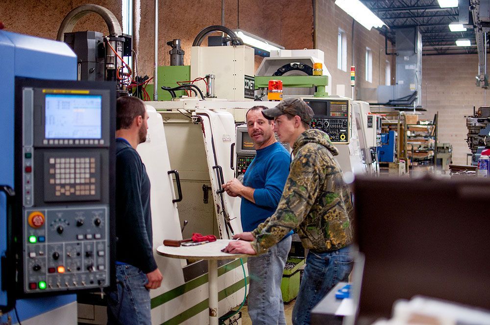 A group of men are working on a machine in a factory.