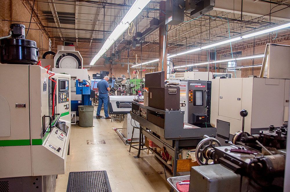 A man is working on a machine in a factory.