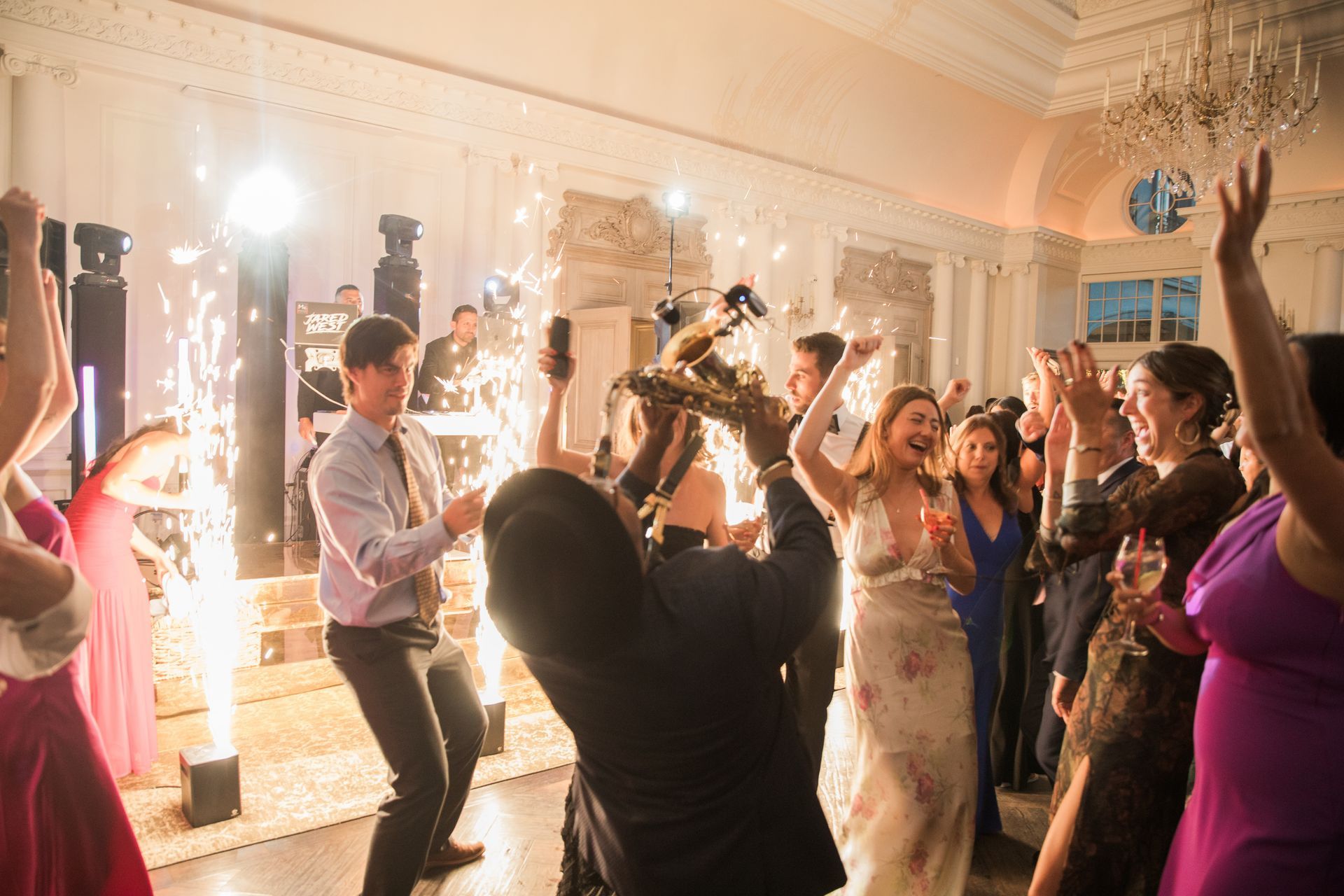 Live sax player performing during a DJ hybrid set on a packed wedding dance floor
