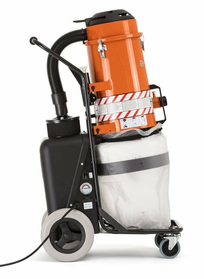 Orange and black industrial vacuum cleaner on a wheeled cart with a long hose.