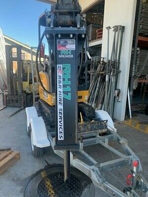 Mini excavator on trailer with hydraulic breaker, labeled 