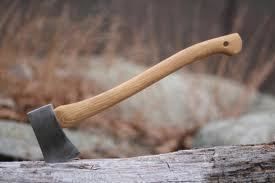 Axe with a wooden handle embedded in a log.