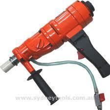 Orange and black pneumatic core drill with a gray hose and handle.