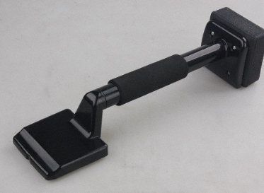 Black carpet knee kicker tool on a white surface.