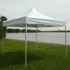 White canopy tent on a grassy area overlooking a body of water.