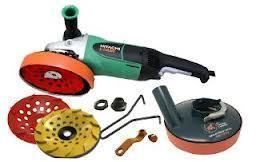 Angle grinder with accessories; green and black tool with orange/red and yellow disks.