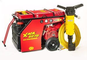 Red XNR SC70 air compressor with jackhammer, coiled hose, and black wheels.