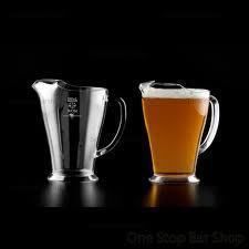 A metal beer pitcher next to one filled with amber beer. Both have handles.