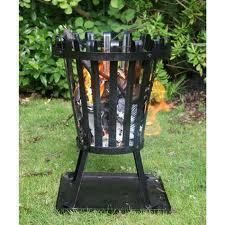 Black metal fire pit on green grass.